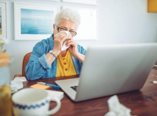 Elderly lady blowing her nose